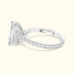 A silver engagement ring featuring a large rectangular diamond and smaller diamonds on the band.