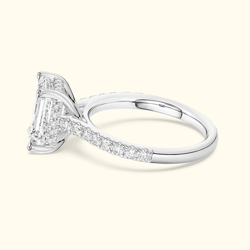 A silver engagement ring featuring a large rectangular diamond and smaller diamonds on the band.