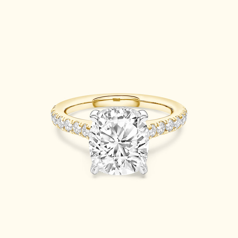 Cushion-cut diamond ring with a yellow gold band and sparkling side stones.