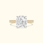 Cushion-cut diamond ring with a gold band and smaller diamonds along the shank.
