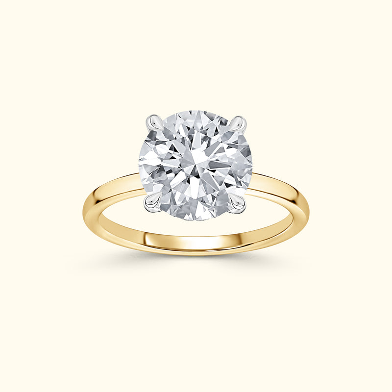 Solitaire engagement ring featuring a large round diamond set in a yellow gold band.