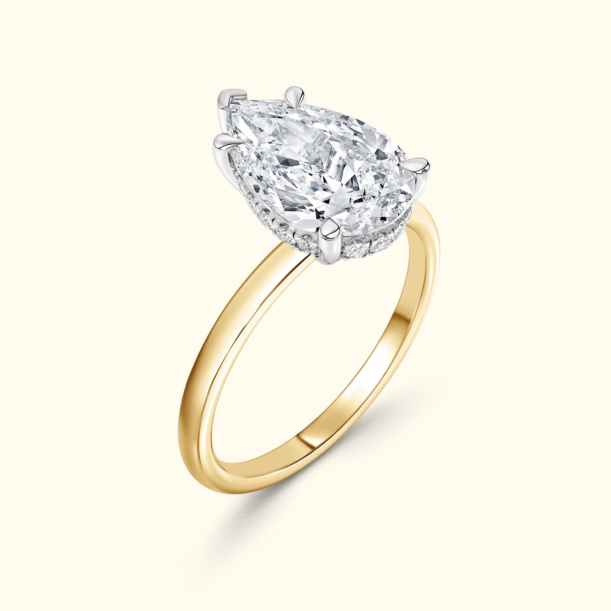 Gold band ring featuring a large pear-shaped diamond centerpiece.