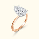 Pear-shaped diamond ring with a rose gold band and silver prongs.