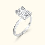 Elegant solitaire ring featuring an emerald-cut diamond set in a sleek silver band.