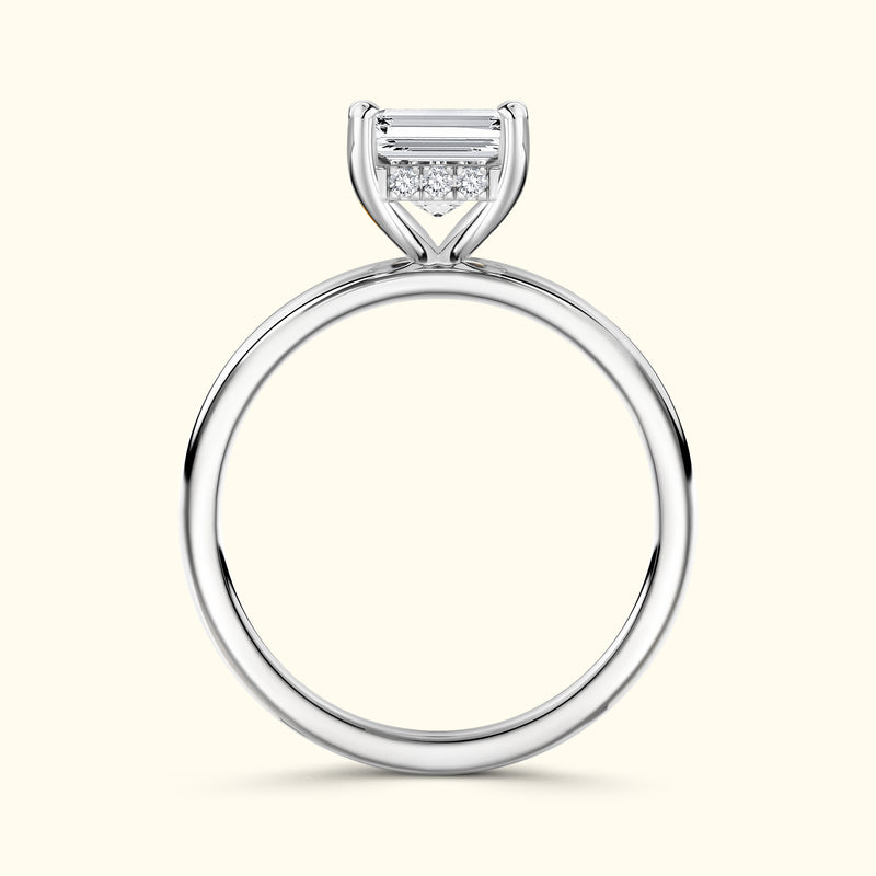 Sleek silver engagement ring featuring a rectangular diamond and smaller accent stones.