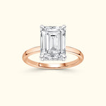 Emerald-cut diamond ring set in a slender rose gold band.