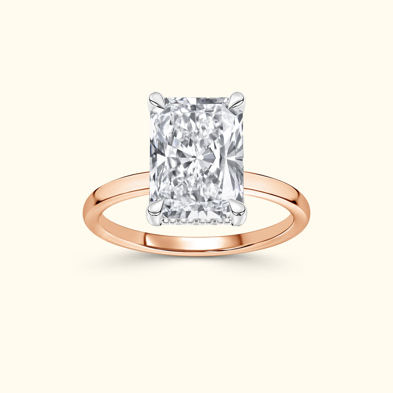 Rectangular diamond ring with a rose gold band, elegantly set against a soft background.