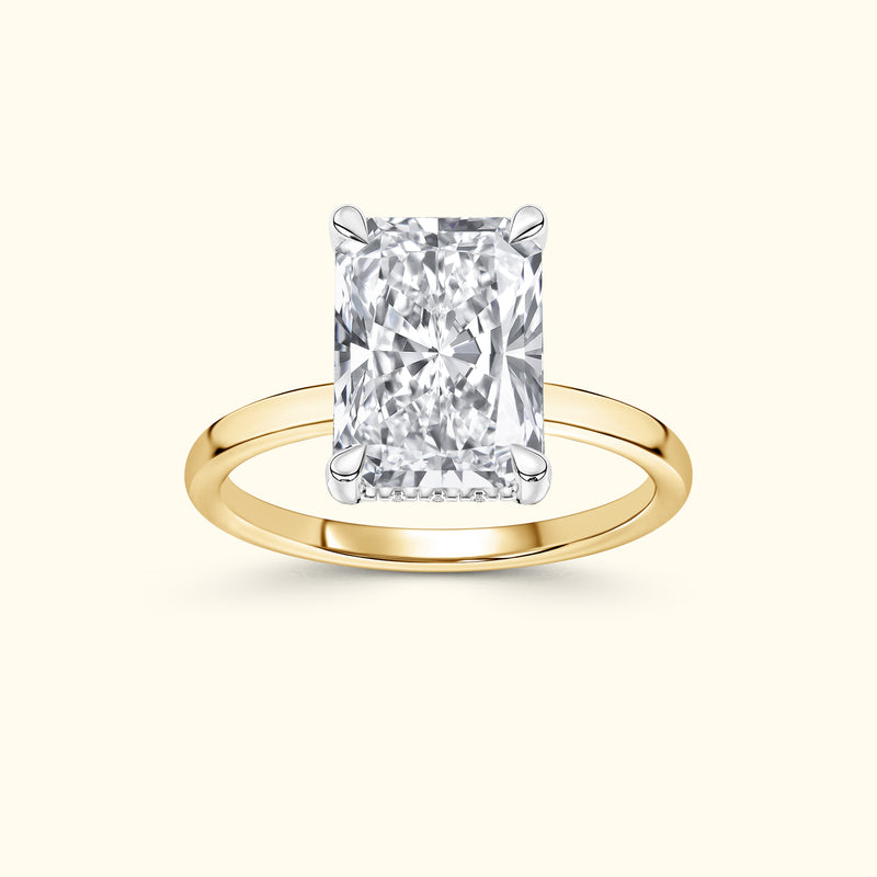 Rectangular diamond engagement ring with a yellow gold band.