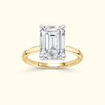 Emerald-cut diamond ring set in a sleek yellow gold band.