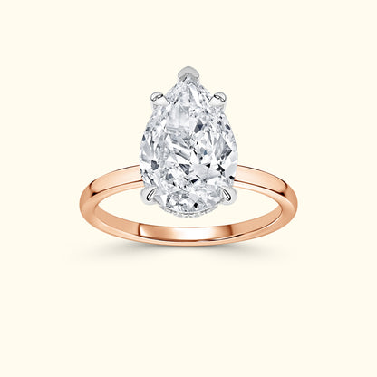 Pear-shaped diamond engagement ring with a rose gold band.