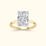 Rectangular diamond ring with a yellow gold band and prong settings.