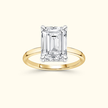 Emerald-cut diamond ring on a simple yellow gold band, elegant and refined.