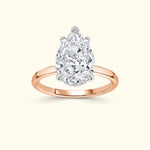 Teardrop diamond engagement ring with a rose gold band.
