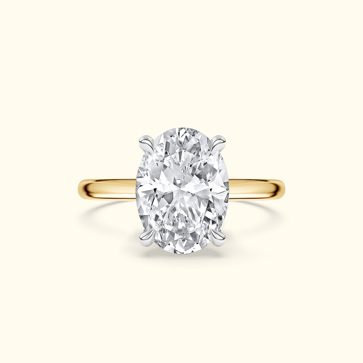 Oval diamond ring with a yellow gold band and four prongs.