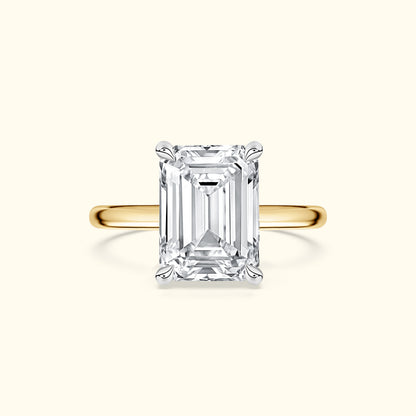 Emerald-cut diamond ring with a yellow gold band.