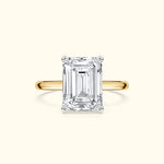 Emerald-cut diamond ring set in a yellow gold band.