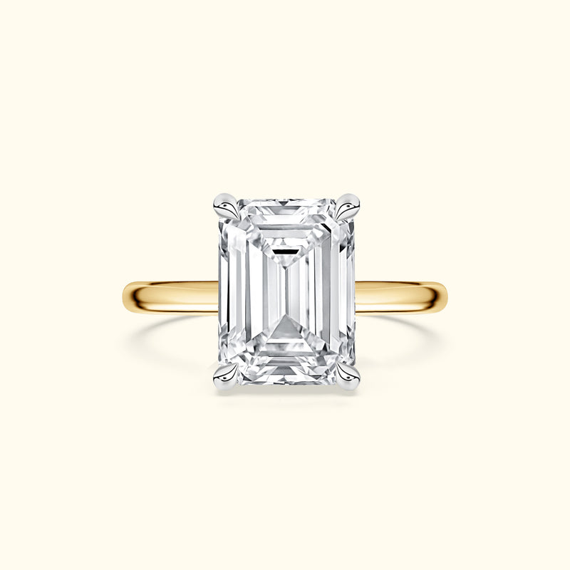 Emerald-cut diamond ring set in a yellow gold band.