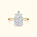 Teardrop diamond ring set in a yellow gold band.