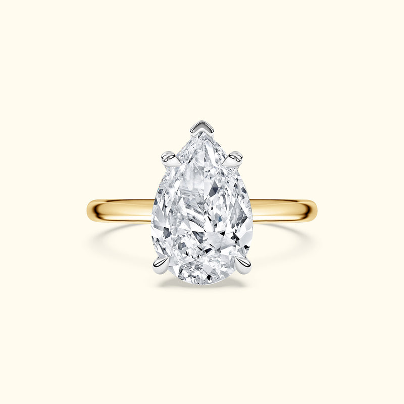 Teardrop diamond ring set in a yellow gold band.