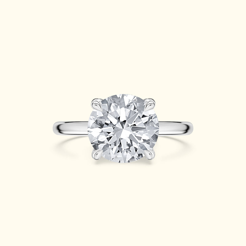 Solitaire diamond engagement ring with a round cut stone on a polished silver band.