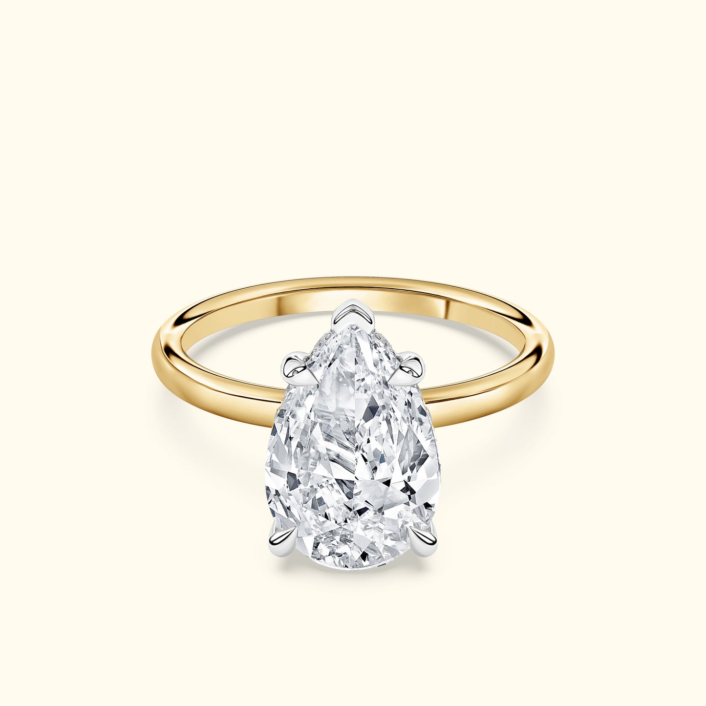 Elegant pear-shaped diamond ring with a yellow gold band and white gold setting.