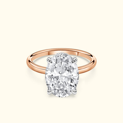 Rose gold ring featuring a large oval diamond center stone.