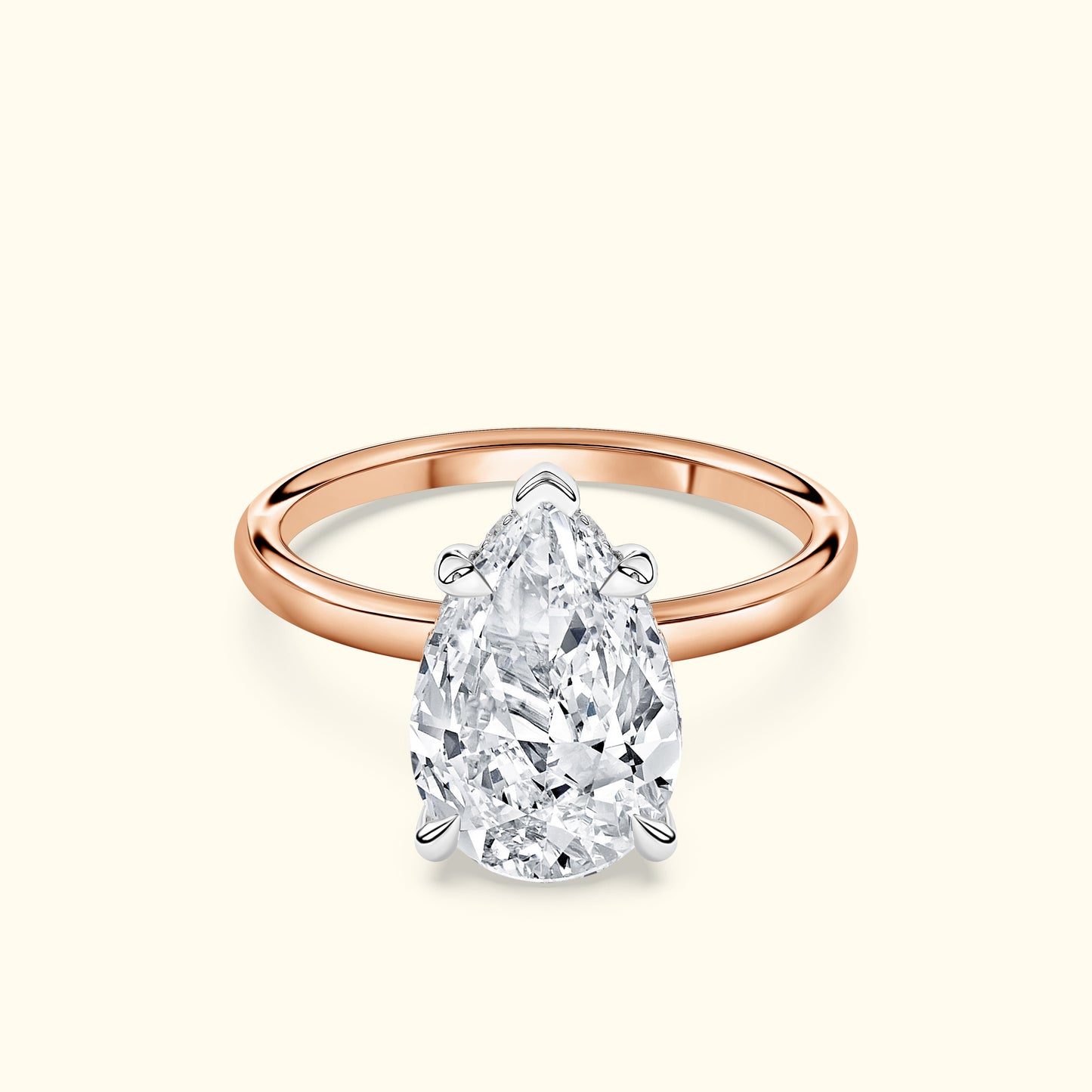 Teardrop diamond ring with a rose gold band and intricate silver setting.