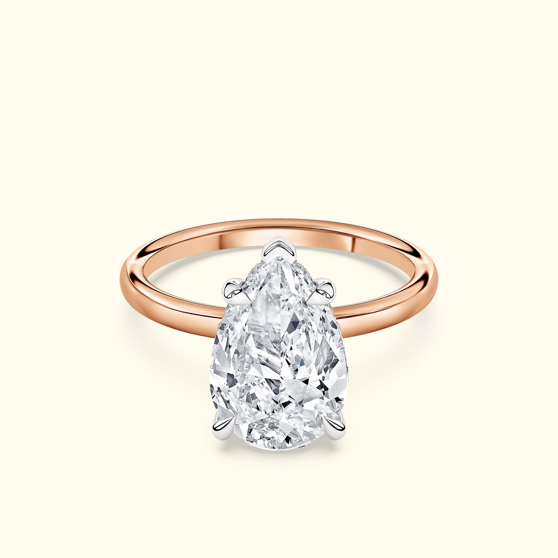 Teardrop diamond ring with a rose gold band and intricate silver setting.