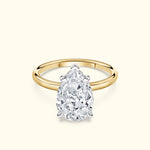 Teardrop diamond ring with a yellow gold band and a polished silver setting.