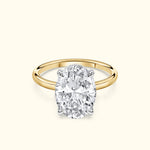 Oval diamond engagement ring with a gold band and silver prongs on a light background.