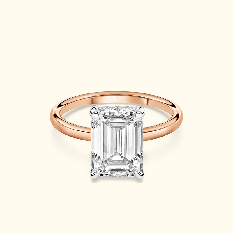 Elegant emerald-cut diamond ring set on a rose gold band.