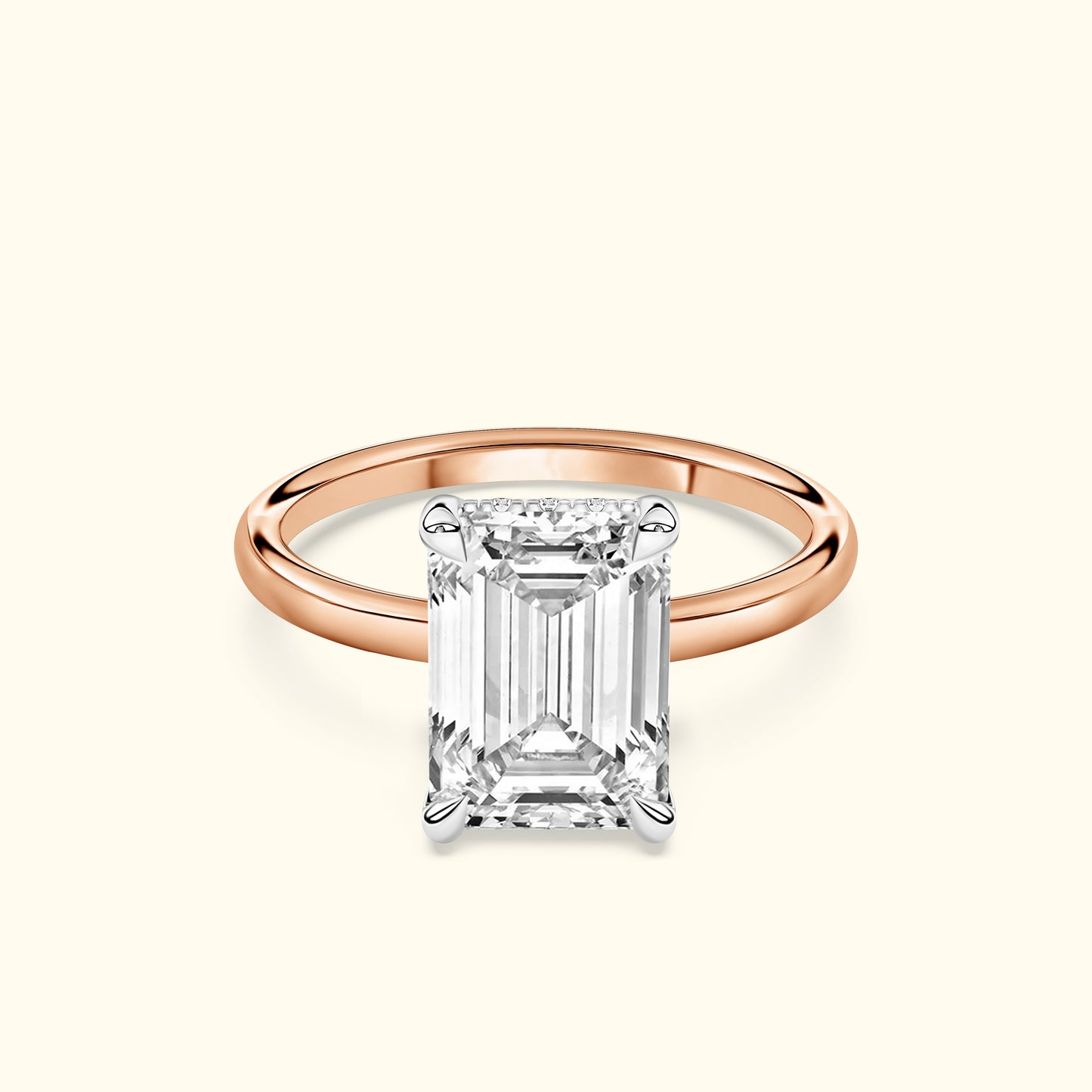 Emerald-cut diamond ring with a rose gold band against a light background.