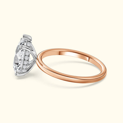 Rose gold ring with a large diamond and accent stones, displayed against a light background.