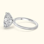 A silver ring featuring a large, sparkling diamond with smaller stones on the band.
