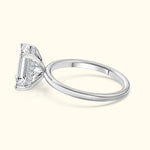Elegant diamond engagement ring with a rectangular cut stone and a sleek silver band.