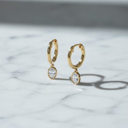 Yellow gold Huggie with a Bezel Set Oval Diamond Drop