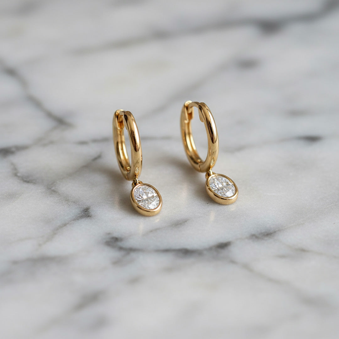 Yellow gold Huggie with a Bezel Set Oval Diamond Drop