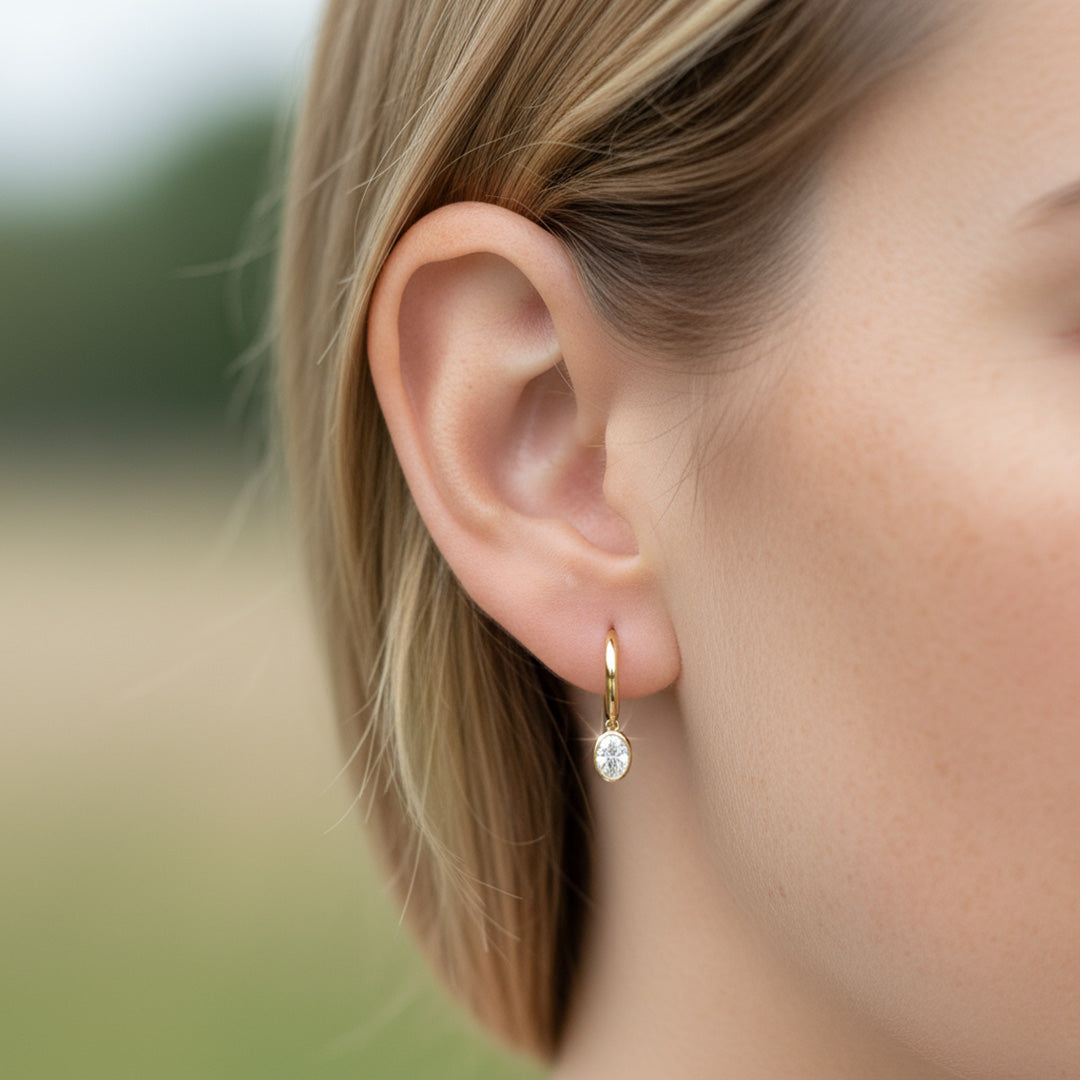 Yellow gold Huggie with a Bezel Set Oval Diamond Drop