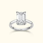 Emerald-cut diamond ring with a sleek silver band, showcasing a timeless elegance.