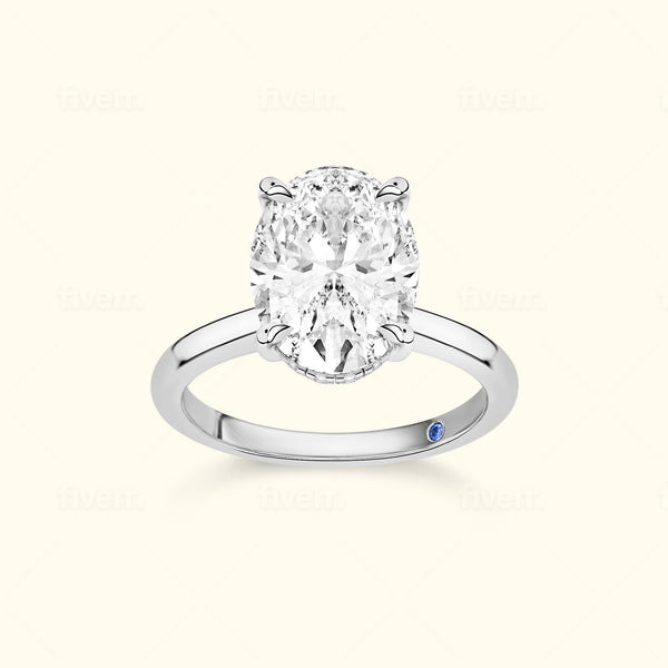 Elegant oval diamond ring set in a polished silver band with a small blue accent.