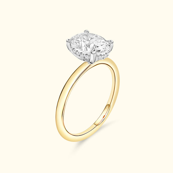 A gold ring featuring a prominent oval diamond set in a classic four-prong setting.