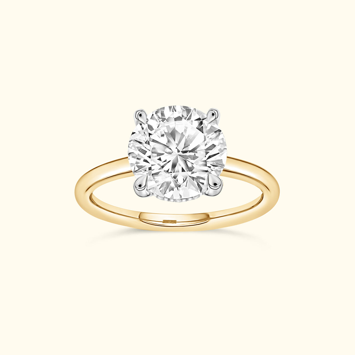Brilliant round diamond engagement ring with a yellow gold band and white gold prongs.