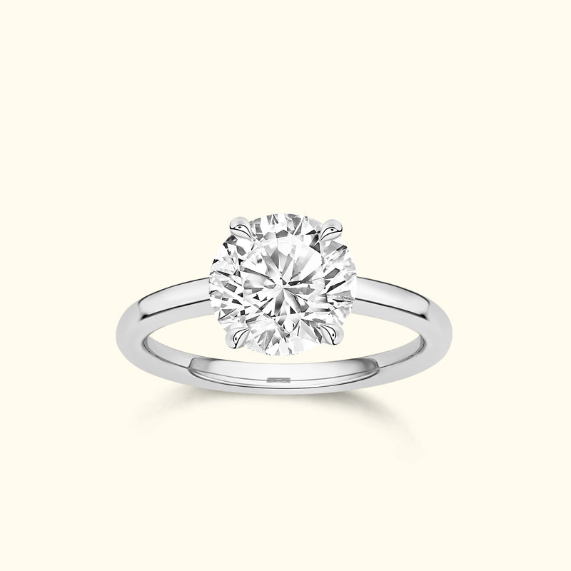 Solitaire diamond ring with a round brilliant cut stone and a polished silver band.