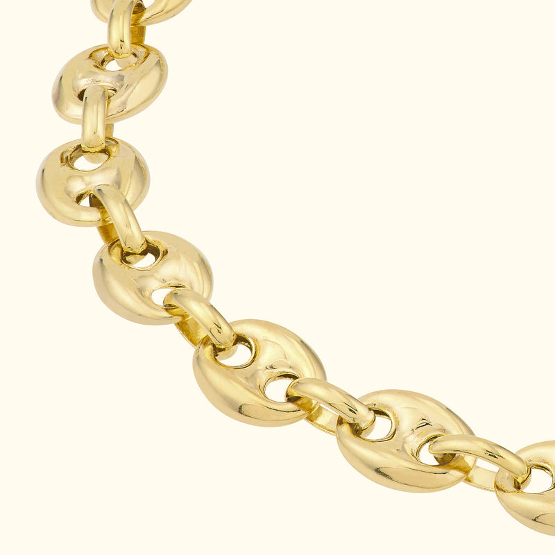 Gold chain necklace with interlocking oval links against a light background.