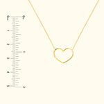 Gold heart-shaped necklace on a delicate chain with a ruler for scale.