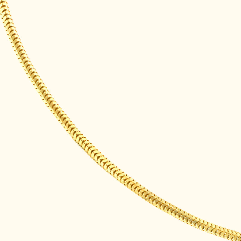 Sleek gold necklace with a flexible, linked design against a light background.