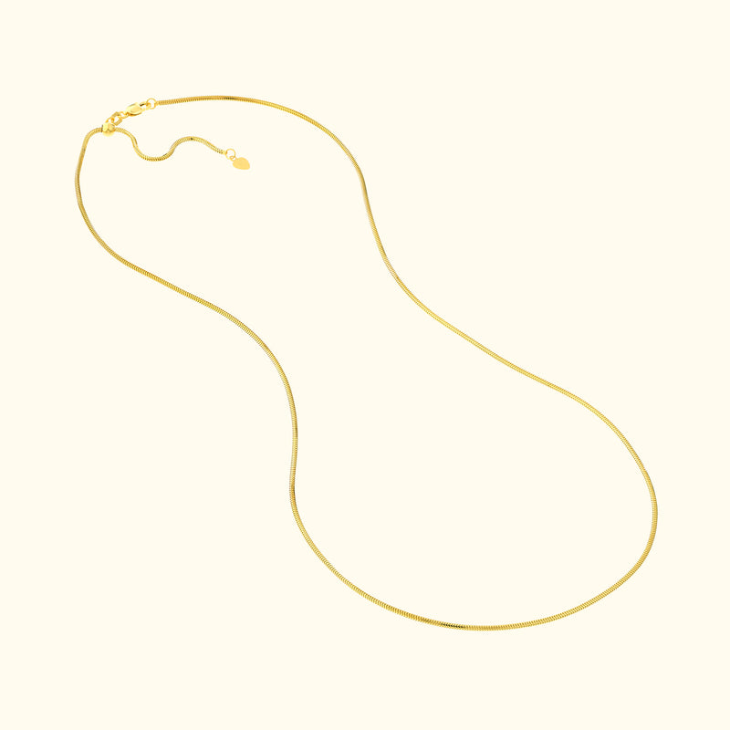 Smooth gold chain necklace with a delicate clasp, elegantly shaped and laid out flat.