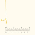 Gold chain necklace with a heart-shaped clasp against a neutral background.