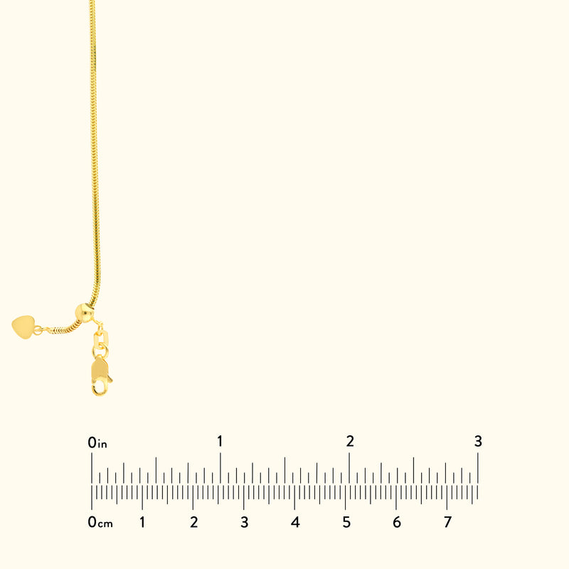 Gold chain necklace with a heart-shaped clasp against a neutral background.