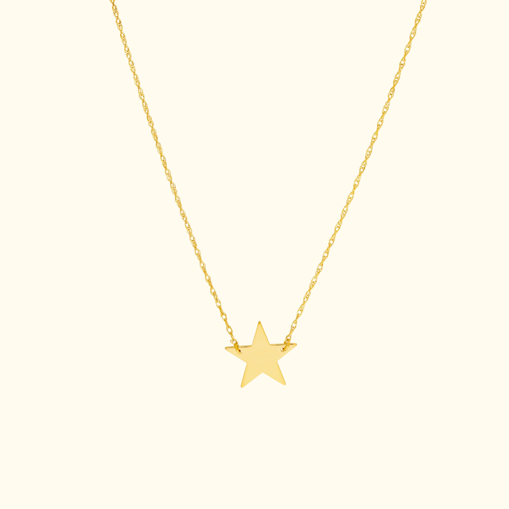 Gold star pendant necklace on a delicate chain.